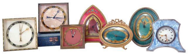 Clocks- 7 (Seven): Two square, easel back Swiss desk clocks, 8 day time and alarm, one with outer case, three "Nuart" desk clocks with faux guilloche enamel, two with easel backs, one with alarm, all 30 hour, a smaller, square Swiss, 8 day, also with easel back, and a Deco style Swiss with silver trimmed case and 8 day movement