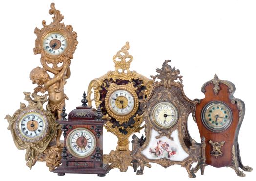 Clocks- 6 (Six): including an Ansonia figural with putto, an Ansonia cartel style, a Hamburg - American with gilt brass case set with porcelain panel featuring putti, a British United with gilt brass case, and two wooden miniatures