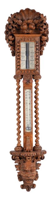 T. Boxell, Brighton, an ornately carved softwood barometer, the base with "green man" mask, trimmed with foliate ornament, beneath a shelf with barley twist columns flanking a thermometer with engraved reamur and fahrenheit scales, the top with engraved barometer scales surrounded by carved trim, and surmounted with a large, removable top carved with scallop shell, fruit and leaves