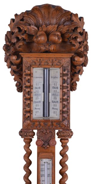 T. Boxell, Brighton, an ornately carved softwood barometer, the base with "green man" mask, trimmed with foliate ornament, beneath a shelf with barley twist columns flanking a thermometer with engraved reamur and fahrenheit scales, the top with engraved barometer scales surrounded by carved trim, and surmounted with a large, removable top carved with scallop shell, fruit and leaves