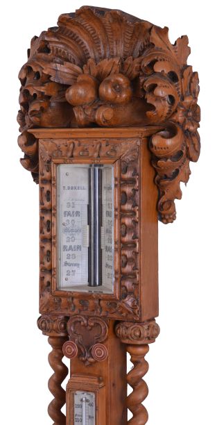 T. Boxell, Brighton, an ornately carved softwood barometer, the base with "green man" mask, trimmed with foliate ornament, beneath a shelf with barley twist columns flanking a thermometer with engraved reamur and fahrenheit scales, the top with engraved barometer scales surrounded by carved trim, and surmounted with a large, removable top carved with scallop shell, fruit and leaves