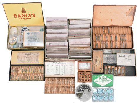 Wrist and pocket watch parts, three large boxes filled with material assortments from various manufacturers, including jewels, staffs, stems, crowns, gaskets, and more, for both Swiss and American watches, together with a box and a metal cabinet each containing hundreds of pocket watch crystals, and a wood pocket watch display case with glass door.