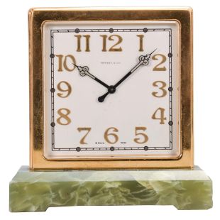 Switzerland, for Tiffany & Co., New York, a two sided desk clock, the rectangular green onyx base supporting the square, gilt case, silvered dials with applied, gilt arabic numerals, luminous black steel hands, 8 day, timepiece movement with lever escapement