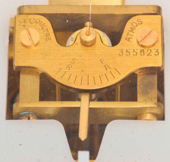 Jaeger- LeCoultre, Switzerland, "Atmos" clock, 15 jewel movement, gilt torsion pendulum, round black painted dial with applied gilt Arabic numerals and arrow markers, gilt hands all contained in a glazed rectangular case with removable front panel, serial #355823.