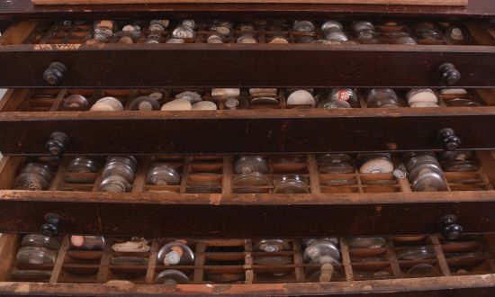 2 (Two) Cabinets of Watch Crystals: one four drawer wood cabinet and one five drawer wood cabinet, both with many pocket and wrist watch crystals. Lot also includes a partial box of crystals.