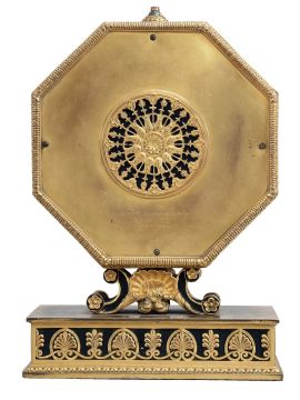 E. F. Caldwell, New York, a gilt and patinated bronze table clock, the base with leaf and dart molding, inset panels with alternating anthemion and palmette ornament, supporting a scallop shell with flanking scrolls and surmounted by the octagonal clock case, also with classical ornament, Roman numeral white enamel dial with central, gilt plaque featuring putti with garlands, gilt, engraved hands, and 8 day Chelsea timepiece movement, serial #134868