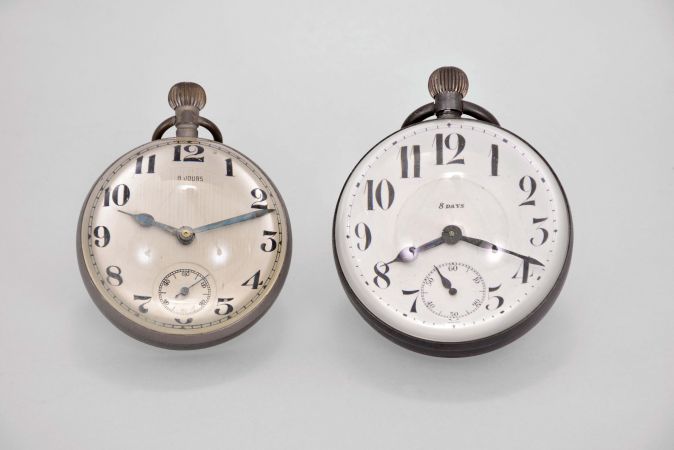 Paperweight clocks- 2 (Two), one marked "Octavia Watch Co.", both with spherical, colorless glass cases and Swiss eight day lever movements, one with Arabic numeral, double sunk white enamel dial, the other with Arabic numeral metal dial, 69mm, 77mm, c1910