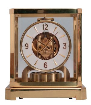 Jaeger- LeCoultre, Switzerland, "Atmos" clock, 15 jewel movement, gilt torsion pendulum, round white painted dial with applied gilt Arabic numerals and arrow markers, gilt hands, serial #212518, c1979.