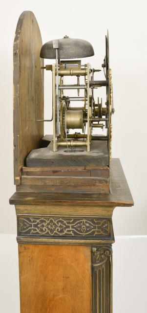 England, miniature tall clock, 8 day, time and strike on bell, weight driven movement in a carved Chinese Chippendale style mahogany case with broken arch top, carved rosettes, center finial, and plinth and foliate carving below molding on the cornice on hood, the dial flanked by two full stop fluted columns with carved capitals above trunk with shaped door and inlaid escutcheon flanked by stop fluted quarter columns with carved capitals resting on a molded base with carved and chamfered corners on ogee style feet. The brass dial has silvered chapter ring, painted moon disc and cast spandrels, signed in center "William Wilks, London"