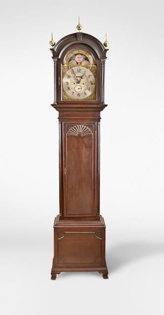 Bailey, Banks, & Biddle, Philadelphia, Penn., an early 20th century Chippendale style tall clock, the dark stained oak case with molded base on ogee bracket feet, the front of the base with applied rectangular mahogany panel with invected corners, trunk with fluted quarter columns flanking a mahogany paneled rectangular door with shell carving, the bonnet with full reeded columns, brass capitals and bases, and molded break arch top with three polished brass ball-and-spire finials, brass composite dial with cast acanthus and palmette spandrels, arabic numeral silvered chapter ring and engraved silvered center, the arch displaying phases of the moon, pierced blued steel hands, substantial eight-pillar three-train brass movement, sounding Westminster quarters on four gongs and counting the hour on a fifth larger gong, three brass weights, and wooden pendulum rod with brass clad bob.
