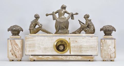 Clocks- 2 (Two) French: (1) France, for Brunott Juwelier, Rotterdam, Netherlands, three piece mantel garniture, 8 day, time and strike, spring driven pendule de Paris movement in an Art Deco case made of white onyx and gray marble, topped with the patinated figure of a woman with outstretched arms flanked by seated musicians on either side, gold painted metal dial, stylized arabic numerals and black steel hands, with two matching side pieces, c1920; (2) France, figural mantel clock, 8 day, time and strike, spring driven pendule de Paris movement in an Art Deco case made of white onyx, black slate, and variegated roseate marble, topped with two large cast German Shepard dog figures, silver colored metal dial with stylized arabic numerals and black steel hands, c1925.