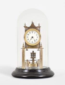 Urania / Jahresuhrenfabrik, Triberg, Germany, 400-day clock, year running, time only, spring driven movement with torsion disc pendulum on brass posts mounted to a black turned wood base, arabic numeral white enamel dial with back steel spade hands, all under a glass dome.