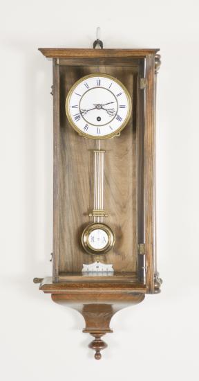 Clocks- 2 (Two): (1) E.N. Welch Manufacturing Co., Forestville, Conn., "Eclipse" wall clock, 8 day, time only with simple calendar, spring driven brass movement in a walnut case with papered metal dial, c1889; (2) Lenzkirch AG, Lenzkirch, Germany, wall clock or "RA" clock, 8 day, time only, spring driven movement in a mahogany veneer case, two-piece roman numeral white enamel dial with black steel hands, c1882.