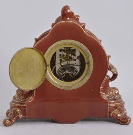 Wm. L. Gilbert Clock Co., Winsted, Conn., "No. 3739" mantel clock, 8 day, time and strike, spring driven movement in a "Japanese Red" porcelain case with gold trimmings, arabic numeral white enamel dial with cast dial center and black steel hands.