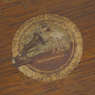 The Gramophone & Typewriter Ltd., 21 City Rd, Finsbury Square, London, England, the English subsidiary of Victor Talking Machine Co., "Type D" oak cased phonograph with original 21" diameter oak horn, 21" resting on an oak and quarter sawn oak record cabinet with single drawer over a single cabinet flanked by full turned columns flanking panels with carved musical trophies. Includes three albums of records.