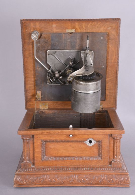 The Gramophone & Typewriter Ltd., 21 City Rd, Finsbury Square, London, England, the English subsidiary of Victor Talking Machine Co., "Type D" oak cased phonograph with original 21" diameter oak horn, 21" resting on an oak and quarter sawn oak record cabinet with single drawer over a single cabinet flanked by full turned columns flanking panels with carved musical trophies. Includes three albums of records.