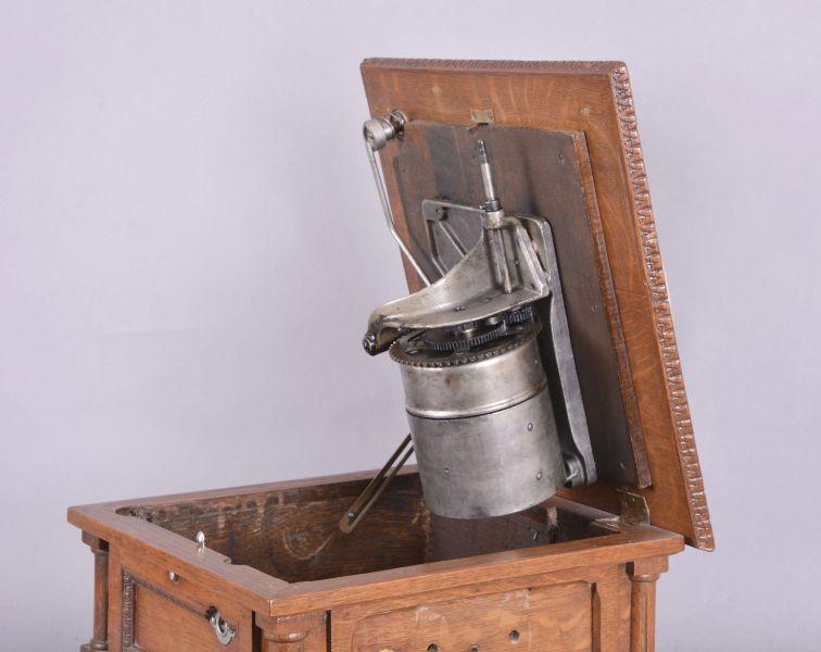 The Gramophone & Typewriter Ltd., 21 City Rd, Finsbury Square, London, England, the English subsidiary of Victor Talking Machine Co., "Type D" oak cased phonograph with original 21" diameter oak horn, 21" resting on an oak and quarter sawn oak record cabinet with single drawer over a single cabinet flanked by full turned columns flanking panels with carved musical trophies. Includes three albums of records.