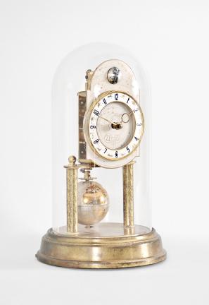 J. Kaiser GmbH, Villingen, Germany, "Universe" 400-day clock, year running, time and moon phase, spring driven brass movement with metallic globe torsion pendulum, monochrome zodiac dial, silver chapter with polished brass numerals, brass hands, all under a glass dome.