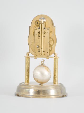 J. Kaiser GmbH, Villingen, Germany, "Universe" 400-day clock, year running, time and moon phase, spring driven brass movement with metallic globe torsion pendulum, monochrome zodiac dial, silver chapter with polished brass numerals, brass hands, all under a glass dome.