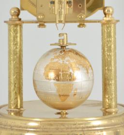 J. Kaiser GmbH, Villingen, Germany, "Universe" 400-day clock, year running, spring driven brass movement with metallic rotating globe torsion pendulum and moon phase dial, monochrome zodiac dial, white chapter with polished brass numerals, brass hands, all under a glass dome.