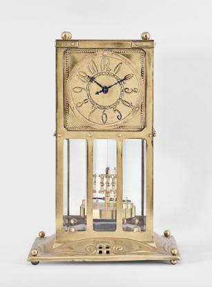 Jahresuhrenfabrik, Triberg, Germany, "Model No. 235"400-day clock, year running, time only, spring driven brass movement with torsion pendulum in an Art Nouveau style brass case with glazed front, sides, and back, brass dial with stylized arabic numerals, black steel hands, and disc pendulum.