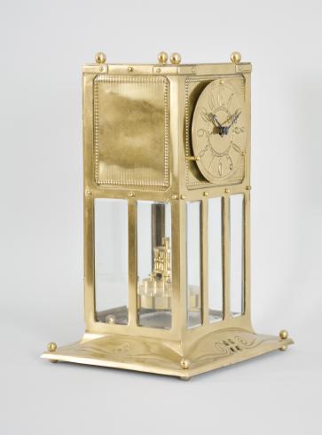 Jahresuhrenfabrik, Triberg, Germany, "Model No. 235"400-day clock, year running, time only, spring driven brass movement with torsion pendulum in an Art Nouveau style brass case with glazed front, sides, and back, brass dial with stylized arabic numerals, black steel hands, and disc pendulum.