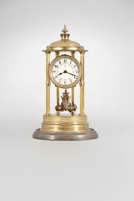 Kienzle GmbH, Schwenningen, Germany, Louvre style 400-day clock, year running, time only, spring driven torsion pendulum movement in a polished brass case with six fluted columns, arabic numeral arcaded enamel dial, all under a glass dome.