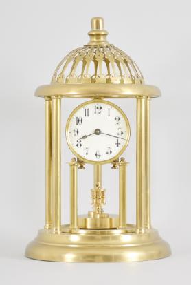 Kienzle GmbH, Schwenningen, Germany, Louvre style 400-day clock, year running, time only, spring driven movement with torsion pendulum and gimbaled suspension mount in a polished brass case with five columns, arabic numeral white enamel dial, all under a glass dome fitted inside of the columns and capped with a pierced dome.