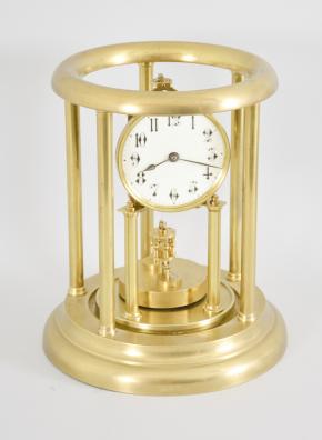 Kienzle GmbH, Schwenningen, Germany, Louvre style 400-day clock, year running, time only, spring driven movement with torsion pendulum and gimbaled suspension mount in a polished brass case with five columns, arabic numeral white enamel dial, all under a glass dome fitted inside of the columns and capped with a pierced dome.