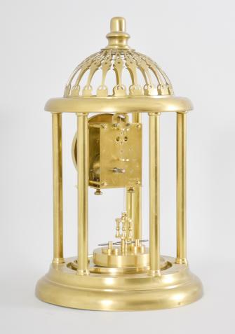 Kienzle GmbH, Schwenningen, Germany, Louvre style 400-day clock, year running, time only, spring driven movement with torsion pendulum and gimbaled suspension mount in a polished brass case with five columns, arabic numeral white enamel dial, all under a glass dome fitted inside of the columns and capped with a pierced dome.