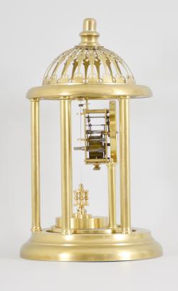 Kienzle GmbH, Schwenningen, Germany, Louvre style 400-day clock, year running, time only, spring driven movement with torsion pendulum and gimbaled suspension mount in a polished brass case with five columns, arabic numeral white enamel dial, all under a glass dome fitted inside of the columns and capped with a pierced dome.