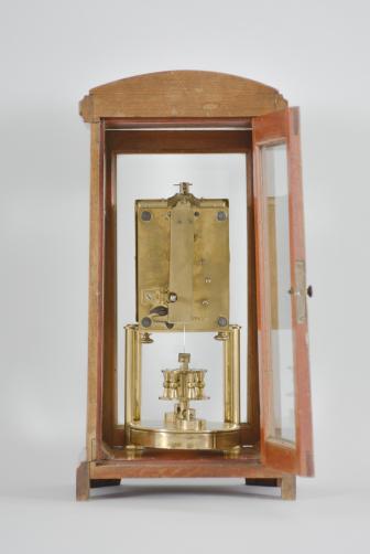 Gustav Becker, Freiburg, Germany for B.H. Abrahams, London, 400-day clock, year running, time only, spring driven brass movement with torsion pendulum in a glazed hardwood case with arch top, arabic numeral silvered dial, and black steel spade hands.

