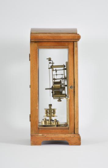 Gustav Becker, Freiburg, Germany for B.H. Abrahams, London, 400-day clock, year running, time only, spring driven brass movement with torsion pendulum in a glazed hardwood case with arch top, arabic numeral silvered dial, and black steel spade hands.

