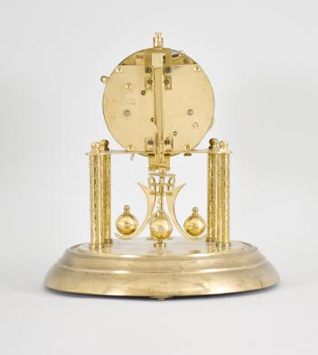 W. Petersen Uhrenfabrik, Schwenningen, Germany, 400-day clock, year running, time and calendar showing day of the week, day of the month, and month, spring driven two-train movement with torsion pendulum on a brass base, arabic numeral painted metal dial, black steel hands.