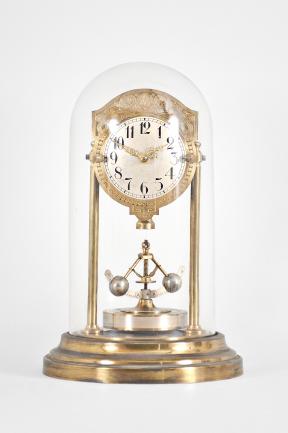 Gebrüder Junghans AG, Schramberg, Germany, 400 day clock, year running, time only, spring driven brass movement with torsion pendulum and deadbeat escapement with Vulliamy pallets, brass base and pillars supporting the movement and convex silvered dial with embossed brass mask, ornate Louis XV style hands, all under a glass dome.