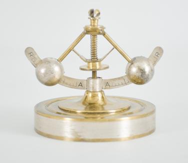 Gebrüder Junghans AG, Schramberg, Germany, 400 day clock, year running, time only, spring driven brass movement with torsion pendulum and deadbeat escapement with Vulliamy pallets, brass base and pillars supporting the movement and convex silvered dial with embossed brass mask, ornate Louis XV style hands, all under a glass dome.