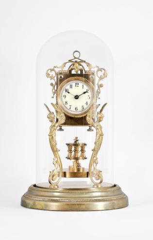 Attributed to Andreas Huber, Munich Germany or Jahresuhrenfabrik, Triberg, Germany, 400 day clock, year running, time only, spring driven movement with torsion pendulum on a brass base with gilt cast caryatid figures supporting the movement, arabic numeral cream enamel dial with black spade hands, all under a glass dome.