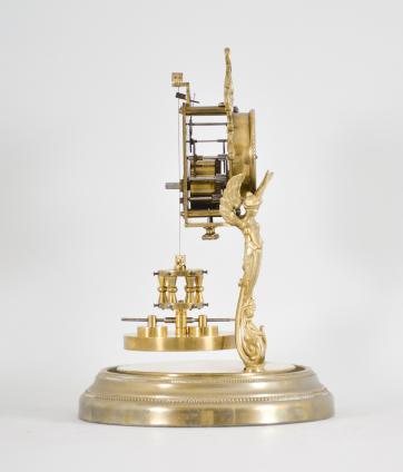 Attributed to Andreas Huber, Munich Germany or Jahresuhrenfabrik, Triberg, Germany, 400 day clock, year running, time only, spring driven movement with torsion pendulum on a brass base with gilt cast caryatid figures supporting the movement, arabic numeral cream enamel dial with black spade hands, all under a glass dome.