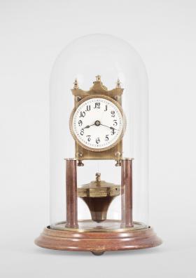 Kienzle GmbH, Schwenningen, Germany, 400-day clock, year running, time only, spring driven brass movement with torsion pendulum and rare Phillip Hauck style pendulum, wood pillars and base, roman numeral white enamel dial with black steel spade hands, all under a glass dome.