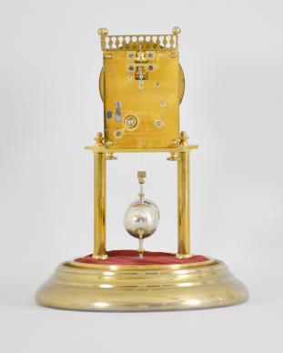 Johann-Christian Bauer and/or Carl Bauer, Fürth, Germany, 400-day clock, year running, spring driven brass movement with torsion pendulum and pinwheel escapement, brass base and posts holding movement and topped by a balustered gallery that sits on the movement plates, arabic numeral white enamel dial reading "Sylvester / anniversary clock", black steel spade hands, and heavy two-ball pendulum, all under a glass dome.