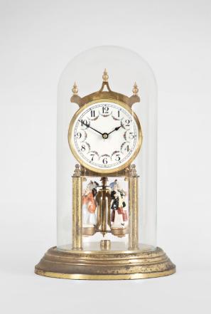 Forestville Clock Co., Germany, 400-day clock, year running, spring driven brass movement with torsion pendulum, brass base and posts holding movement, arabic numeral arcaded white enamel dial, black steel spade hands, and pendulum with ceramic dancing figures, all under a glass dome. 










