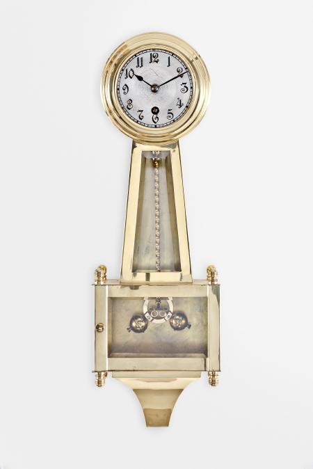 Urania / Kienzle GmbH, Schwenningen, Germany, hanging 400-day banjo clock, year running, front-wound spring driven movement with torsion pendulum in polished brass case with beveled glasses, arabic numeral silvered metal dial, and black steel hands.