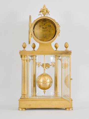 C. Grivolas & Cie., Paris, France, "Pendule 400 Jours" or 400-day clock, year running, spring driven movement with torsion pendulum in a fancy Louis XVI gilt bronze case with four fluted columns before three curved beveled glasses, roman numeral polychrome enamel dial with pierced brass hands, spherical gilt pendulum with extension rod.