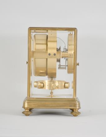 Jean Leon Reutter / Jaeger LeCoultre, an early model K2 shelf or mantel clock, the gilt brass case with molded base on turned feet, and ovolo molded frame set with five bevelled glasses, roman numeral white enamel dial signed "Atmos Pendule Perpetuelle" below 12:00, and " Brevets J. L. Reutter Made in France" below 6:00, blued steel Breguet style hands, 16 jewel, nickel plated LeCoultre cal. 30A movement with lever escapement, gilt, pivoted drum containing a mercury and ammonia filled glass U tube, rocking with changes in temperature and thereby rewinding the mainspring, and large, gilt, torsion pendulum with temperature compensation attachment, movement serial #1176, frame serial #1467