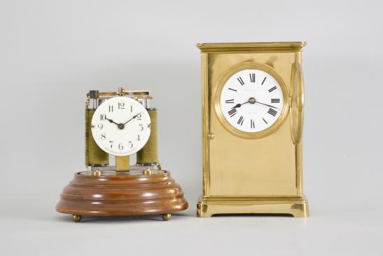 Clocks- 2 (Two), both electromechanical, the first signed "Electric- Silentia Besancon", polished brass crystal regulator style case with mirrored back, roman numeral white enamel dial with black steel hands, round, jeweled watch movement with large balance with horseshoe magnet and rotor below, rewinding the small mainspring barrel every 45 minutes, serial #64, the other by the "Prentiss Clock Improvement Co.", arabic numeral white enamel dial and round brass pin lever movement mounted to a strip brass frame, flanked by two electromagnetic coils, periodically energized and resetting a pivoted horizontal bar with coil spring, it