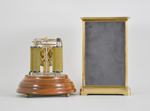 Clocks- 2 (Two), both electromechanical, the first signed "Electric- Silentia Besancon", polished brass crystal regulator style case with mirrored back, roman numeral white enamel dial with black steel hands, round, jeweled watch movement with large balance with horseshoe magnet and rotor below, rewinding the small mainspring barrel every 45 minutes, serial #64, the other by the "Prentiss Clock Improvement Co.", arabic numeral white enamel dial and round brass pin lever movement mounted to a strip brass frame, flanked by two electromagnetic coils, periodically energized and resetting a pivoted horizontal bar with coil spring, it