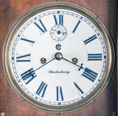 Clocks- 2 (Two) American: (1) wall clock with Waterbury Clock Co. No. 22, time only, double weight driven movement in associated period mahogany case; (2) E. N. Welch Mfg. Co., Forestville, Conn., "Violet", 30 hour, time and strike, spring brass movement shelf clock