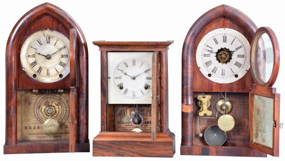 Clocks- 3 (Three): (1) Atkins Clock Co., Bristol, Conn., "Cottage XX" shelf clock with a spring driven, 8 day, time and strike movement in a rosewood veneered case, c1860; (2) Brewster & Ingrahams, Bristol, Conn., "Round Gothic" or "Beehive" shelf clock with a spring (brass) driven, 8 day, time and strike movement in a mahogany veneered case, c1848. (3) William L. Gilbert, Winchester, Conn., "Beehive" shelf clock with a spring driven, 8 day time, strike and alarm movement in a rosewood veneered case, c1850.