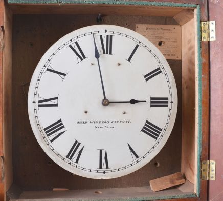 Clocks- 2 (Two) Self-Winding: (1) Self-Winding Clock Co., New York, "No. 18" electrically-wound wall clock in a stained birch case, c1910; (2) Self-Winding Clock Co., New York, electrically-wound gallery clock with 13 inch dial in a wood case.