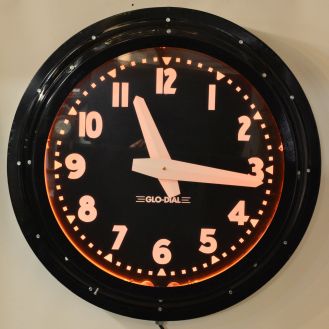 Glo-Dial Clock Company, Los Angeles, California, neon gallery wall clock, electric driven, time only movement with large 25.5in black dial, bold straight white hands, Arabic numerals and orange lighted neon perimeter